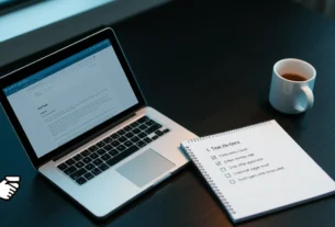 Desk with laptop, email draft, notepad, coffee mug, handshake icon.